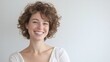 © WS Studio 1985 - Joyful Young Woman with Curly Hair Smiling Against Light Background