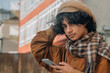 © tetxu - Smiling young man using smartphone on the street
