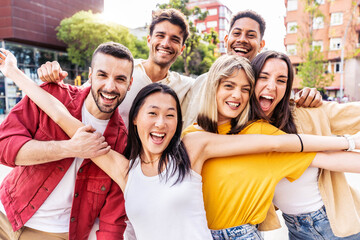 Wall Mural - Multiracial young people smiling at camera outside - Happy group of friends having fun hanging out in city street