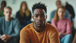 © standret - Thoughtful man in support group session with serious expression