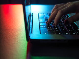 Hacker working on laptop at desk