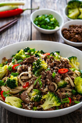 Wall Mural - Udon noodles with minced beef and broccoli on wooden table