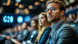 © Anastasia - Businesspeople attending a G2B town hall on small enterprise subsidies, with 'G2B' displayed on digital panels.