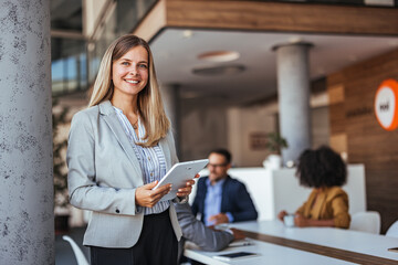 Confident Businesswoman Holding Tablet in Office Environment