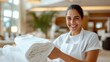 © LifeMedia - A friendly hotel staff member stands with freshly laundered linens, emphasizing the welcoming nature of the hospitality industry, in a bright modern hotel environment.