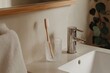 © Atlas Studio - Modern bathroom setting featuring a toothbrush, glass holder, and sleek faucet on a stylish countertop