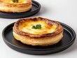 © artiiz - A sleek black plate showcasing a Portuguese pastel de nata dessert with a crispy, flaky crust filled with creamy egg custard and caramelized top dessert, Photorealistic