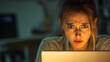 © Chanwit - Intense focus on laptop young woman's concentration home office digital work environment nighttime setting emotion-driven scene