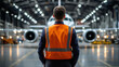 © Maksym - A bright hangar showcases a private jet with an airport worker in a safety vest standing confidently at the forefront, exuding expertise and authority.
