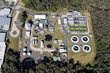 © AmazingAerialAgency - Aerial view of modern water treatment plant with tanks and surrounding forest, Warana, Australia.