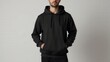 © ArtPro - Mockup black blank hoodie displayed on a standing model, with soft natural lighting accentuating the simple, clean design in a minimal studio environment.