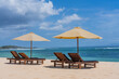 © Travel 'n' Lifestyle - View of tranquil Nusa Dua beach with sun loungers and umbrellas under a clear blue sky, Bali island, Indonesia.