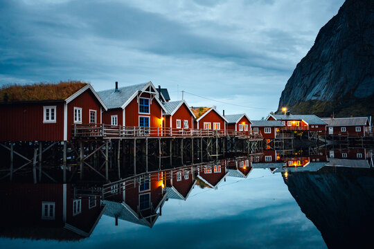 Charming Red Cabins Nestled by a Serene Fjord, Captivating at Dusk in Norways Landscape