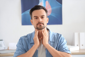 Wall Mural - Young man self-examining thyroid gland in clinic, closeup