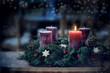 © Maren Winter - Advent wreath with the first lit candle and Christmas decoration outdoors in a patio at night in bluish light, snowy bokeh, copy space, colorized photo, selected focus