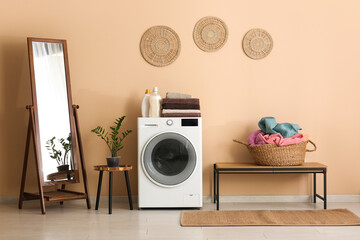 Wall Mural - Modern washing machine, mirror, houseplant and basket with laundry in room