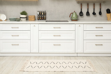 Canvas Print - Stylish soft rug on wooden floor in kitchen