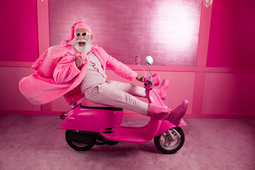 Wall Mural - Full size portrait of eccentric crazy man wear pink santa outfit hold gifts sack drive bike studio corridor background