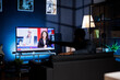 © DC Studio - Concerned citizen watching breaking news program on tv, sitting on sofa and listening to newscaster explain latest worldwide events. Young adult following daily media headlines.