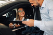© Zamrznuti tonovi - Smiling interaction of man and woman with tablet in car dealership