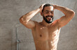 © Prostock-studio - Portrait Of Happy Muscular Bearded Man Washing Hair And Body Using Male Shampoo Taking Hot Shower Standing Under Water Rain In Modern Bathroom At Home. Men's Beauty Routine And Hygiene Concept