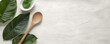 © Pornphan - Sustainable living with green leaves and wooden spoon on light background