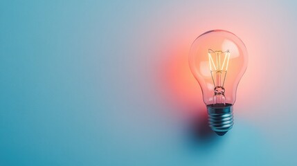 Poster - Vintage Light Bulb Glowing Against a Soft Blue Background, Illuminating the Space with Warmth and Nostalgia, Perfect for Home Decor and Creative Projects