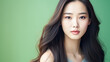 © ALA - Portrait of smiling asian teenager girl green background.