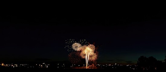 Aufkleber - Colorful fireworks display illuminating the night sky with vibrant bursts and sparkling effects over a serene landscape