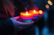 © GHM_STUDIO - Hands holding rainbow candles during pride vigil