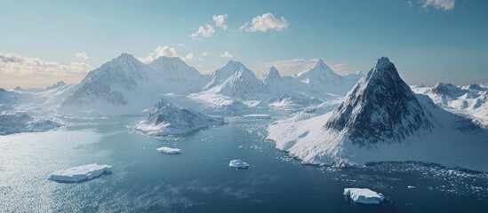 Poster - Majestic snow covered mountains and glaciers overlooking a tranquil blue ocean with floating icebergs in a serene winter landscape