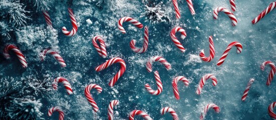 Poster - Festive candy canes scattered over a snowy backdrop creating a cheerful Christmas holiday theme from an overhead perspective.
