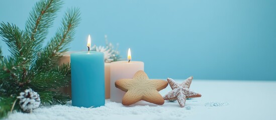 Poster - Christmas gingerbread cookies with candles gift and spruce branches on white table against blue background festive holiday arrangement