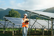 © Deemerwha studio - Female engineer in uniform with solar panel is working check and notepad quality in solar farm. solar green energy technology. Clean alternative or renewable power sources concept