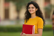© Niks Ads - young indian female college student holding text book