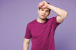 © ViDi Studio - Young sad sick ill tired Caucasian man wear violet t-shirt casual clothes put hand on forehead suffer from headache isolated on plain pastel light purple background studio portrait. Lifestyle concept.