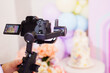 © Maria - A professional video camera is filming a birthday cake. blurred background.