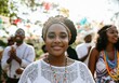 © Running opossum - Young black woman smiling at a summer festival, with friends clapping and celebrating in the background