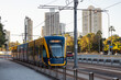 © Austockphoto - The G:link light rail tram on the Gold Coast passing station with Surfers Paradise buildings