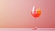 © AbstractAI - Cocktail glass filled with vibrant Aperol spritz garnished with orange slice against a soft pastel background with ample copy space for text.
