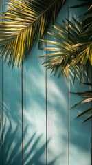 Wall Mural - Palm leaves casting shadows on a blue wooden background in bright daylight