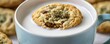 © porpia - A cannabis-infused chocolate chip cookie dipped in milk, showcasing a cannabis bud on top, perfect for edible relaxation concepts.
