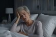© useful pictures - Elderly woman struggling with insomnia while resting in bed at night in a softly lit bedroom