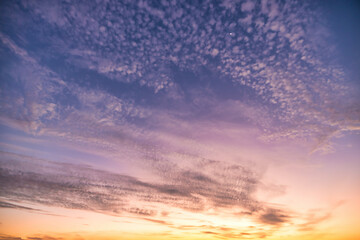 Wall Mural - a beautiful sky tinted by the sun leaving vibrant shades of gold, pink, blue and multicolored. cloud