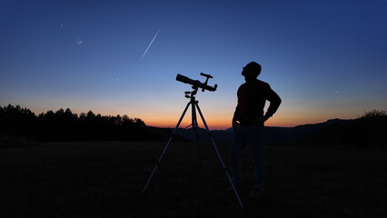 Wall Mural - amateur astronomer looking at the evening skies, observing planets, stars, moon and other celestial 