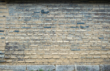 Wall Mural - Aged brick wall background constructed from clay, mud, bricks and ceramic decorative elements.