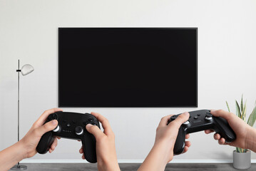 Aufkleber - Two players holding gamepad in front of a TV with a blank screen, designed for video game promotion and mockup presentations