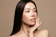 © Beauty Agent Studio - Beauty side portrait of Asian model with a clean glowing skin and long straight black hair is posing against beige background. Skincare, Auurveda and spa concept