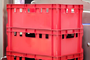 Poster - Two red plastic boxes stacked on top of each other. The boxes are empty