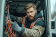 © Serhii - Bearded Electrician Loading Cable Equipment from His Van at a Construction Site